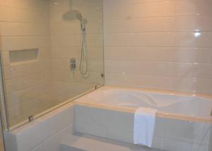 a bathroom with a bath tub and a shower at Commander Suites de Boracay in Boracay