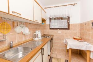 a kitchen with a sink and a counter top at Apartment Jasna summer barbeque in Srima +19 photos
