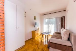 a living room with a couch and a window at Apartment Jasna summer barbeque in Srima