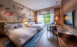 a hotel room with two beds and a desk at Hard Rock Hotel Desaru Coast in Desaru