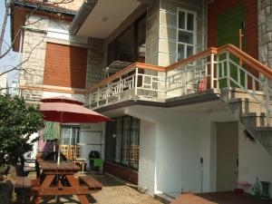 un edificio con balcón y mesa con sombrilla en Birdsnest Hostel Hongdae Foreigner only, en Seúl