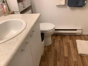 Baño blanco con aseo y lavamanos en home stay, en Victoria