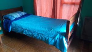 1 cama con edredón azul en una habitación en Hostel Luna Country en El Chaltén