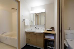 AshoroHotel REUS Ashoro的带水槽、浴缸和镜子的浴室