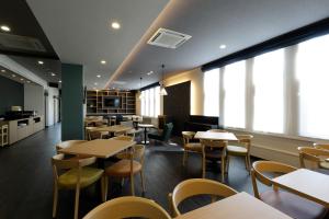 AshoroHotel REUS Ashoro的有桌椅和窗户的餐厅