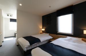 AshoroHotel REUS Ashoro的有两张床和一扇窗户的酒店房间