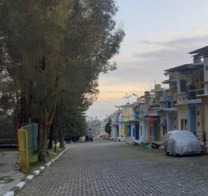 a cobblestone street in a town with houses and trees at Villa Berastagi Highland No 8-i in Berastagi