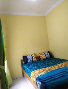 1 dormitorio con 1 cama con sábanas azules y doradas en Villa Berastagi Highland No 8-i, en Berastagi