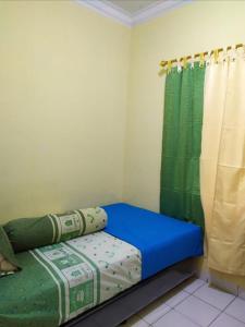a small room with a bed and a shower at Villa Berastagi Highland No 8-i in Berastagi