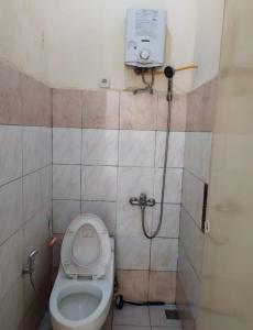 a small bathroom with a toilet and a shower at Villa Berastagi Highland No 8-i in Berastagi +3 photos