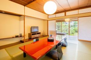 - un salon avec une table rouge et une télévision dans l'établissement Art Hotel Kokura New Tagawa, à Kitakyūshū