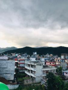vistas a una ciudad con edificios y montañas en Hotel Aarjan And Restaurant en Pokhara