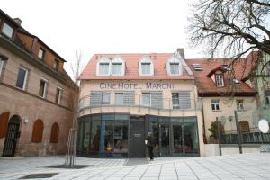a man is standing in front of a building at CineHotel Maroni in Zirndorf