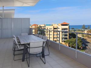 a balcony with a table and chairs on a balcony at Karmasea 43 in Alexandra Headland