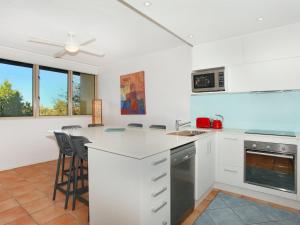 a kitchen with white cabinets and a counter top at Little Hill 3 River Side 2 Bedroom Apartment across the road to the beach in Mooloolaba