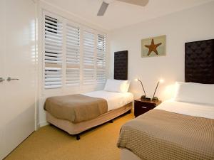 um quarto com 2 camas e uma janela em Mariner Cove 1 em Mooloolaba