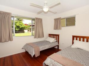 1 dormitorio con 2 camas y ventilador de techo en Oloway 40, en Alexandra Headland