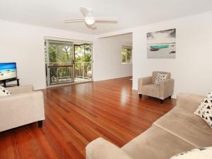 a living room with a hard wood floor and a couch at Oloway 40 in Alexandra Headland