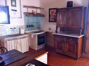 a kitchen with wooden cabinets and a stove at Residenza d'Epoca La Commenda in Manciano