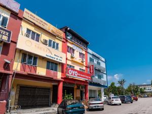 une rangée de bâtiments dans une rue avec des voitures garées dans l'établissement Super OYO 432 My 7days Inn, à Johor Bahru