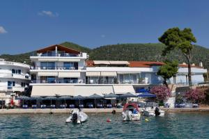 un gran edificio con barcos en el agua de enfrente en Hotel Mike, en Palaia Epidavros