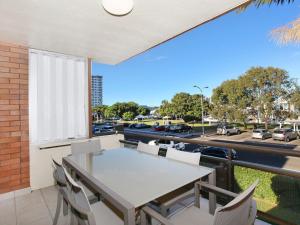 a balcony with a table and chairs and a view of a parking lot at Riverview II 3 in Mooloolaba
