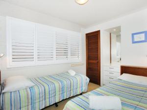 a bedroom with two beds and a mirror at Riverview II 3 in Mooloolaba