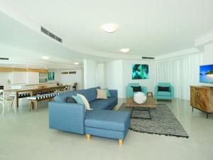 a living room with a blue couch and a table at Sirocco 201 in Mooloolaba