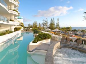 a swimming pool with chairs in a building at Sirocco 506 in Mooloolaba