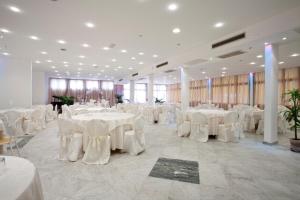 a banquet hall with white tables and white chairs at Grappolo D'Oro in Pietrasanta +37 photos