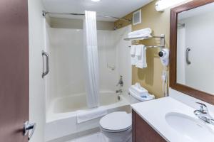 a bathroom with a sink and a toilet and a tub at Quality Inn & Suites Plattsburgh in Plattsburgh
