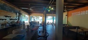 un restaurante con una fila de mesas y sillas en Bong's Guesthouse M'Pai Bay en Koh Rong Sanloem