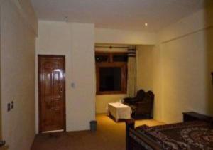 Habitación con cama, sofá y silla en Tourist Inn Hotel en Shogran