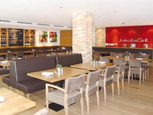 a restaurant with wooden tables and chairs and a bar at Seligweiler Hotel & Restaurant in Ulm