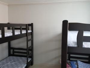 Ce lit se trouve dans un dortoir doté de 2 lits superposés et d'un mur. dans l'établissement Guest House Manna, à Daegu
