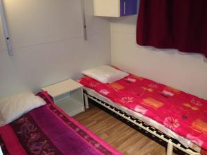 Habitación pequeña con 2 camas y mesa. en Domaine Plein Sud, en Bruzac