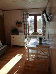 a kitchen with a table and chairs and a window at Willa Rosiczka in Okuninka