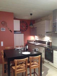 uma cozinha com uma mesa preta e cadeiras em Johnson's house les pieds dans l'eau em Saint-Aubin-sur-Mer