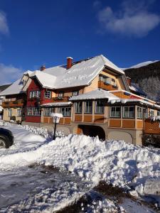 a large house with snow in front of it at Edelsteinhotel Guniwirt in Krakaudorf