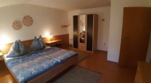 um quarto com uma cama com um edredão azul em Haus Königshofer em Neusiedl am See