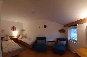 um quarto com duas camas e duas cadeiras e uma janela em Haus Königshofer em Neusiedl am See