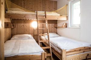 2 Etagenbetten in einem kleinen Zimmer mit Fenster in der Unterkunft Hüttendorf Präbichl in Vordernberg