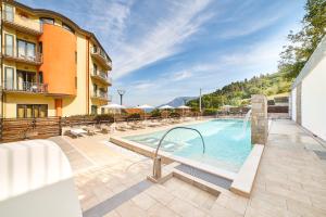 een zwembad met stoelen en een gebouw bij La Collina Hotel & Spa in Oliveto Citra