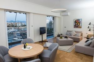 ein Wohnzimmer mit einem Tisch und Stühlen in der Unterkunft Piraeus Seaview Elegant Apartments in Piräus