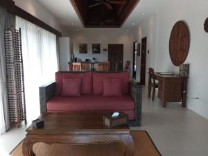 a living room with a red couch and a table at Koh Phangan Pavilions Serviced Apartments in Thong Nai Pan Noi