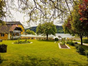 ミルシュタットにあるホテル シーヴィラの家と湖のある広い庭