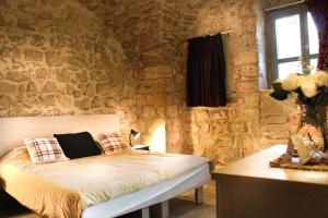 ein Schlafzimmer mit einem Bett in einer Steinmauer in der Unterkunft Al-Hakim Boutique Hotel Old Town Nazareth in Nazareth