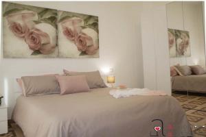 um quarto com uma cama com rosas cor-de-rosa na parede em CASACRIZIA em Cagliari