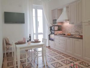 a kitchen with a white table and a table and chairs at CASACRIZIA in Cagliari