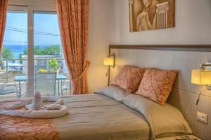a bedroom with a bed with a view of a balcony at Haraki Bay Hotel and Luxury Apartments in Haraki